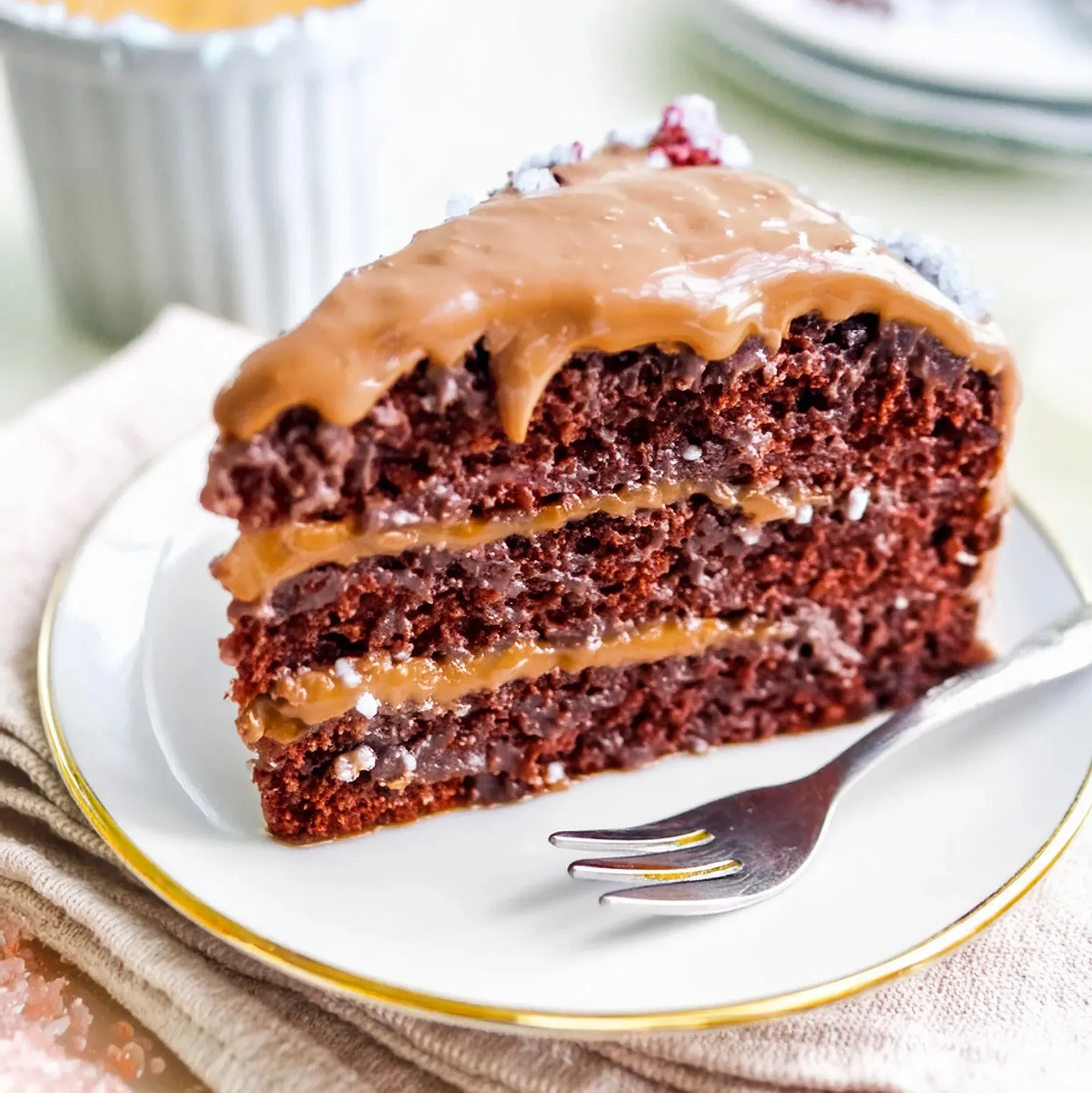 A slice of Decadent Caramel Bliss Cake with rich chocolate layers and creamy caramel frosting