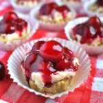 A plate of Luscious Cherry Cheesecake Bites topped with a dollop of cherry filling